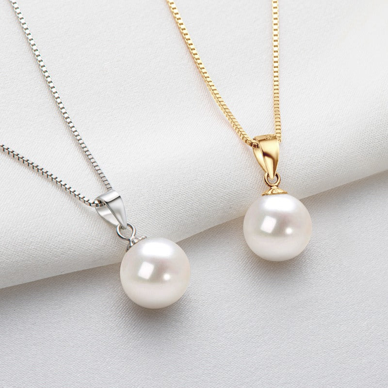 Two pearl necklaces, one silver and one gold, on a white fabric background.